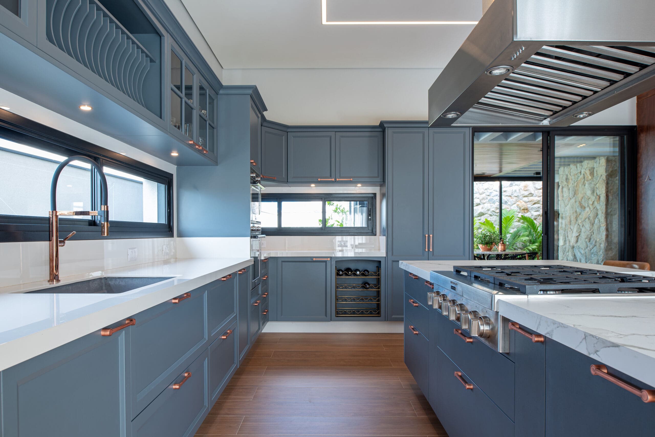 Cozinha em estilo provençal, com armários na cor azul, bancada revestida em Silestone na cor branca